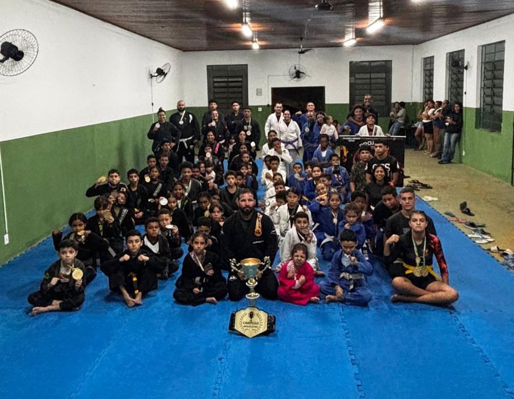 Equipe reunida no tatame com cinturão de campeão brasileiro