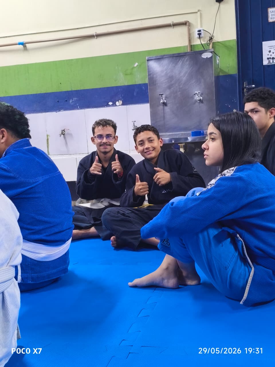 Alunos descontraídos no tatame após o treino