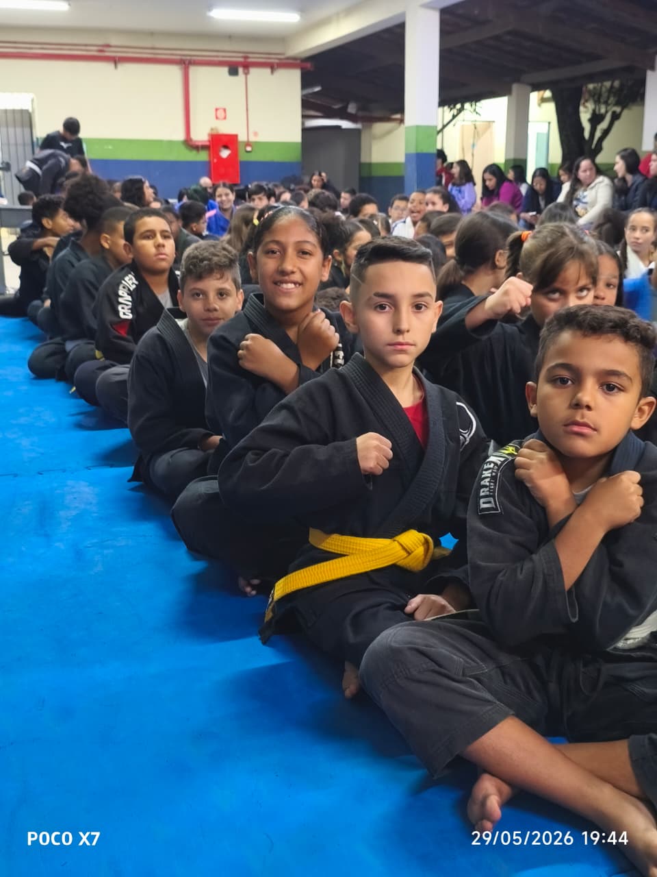 Fileira de alunos kids com kimono preto e faixa amarela