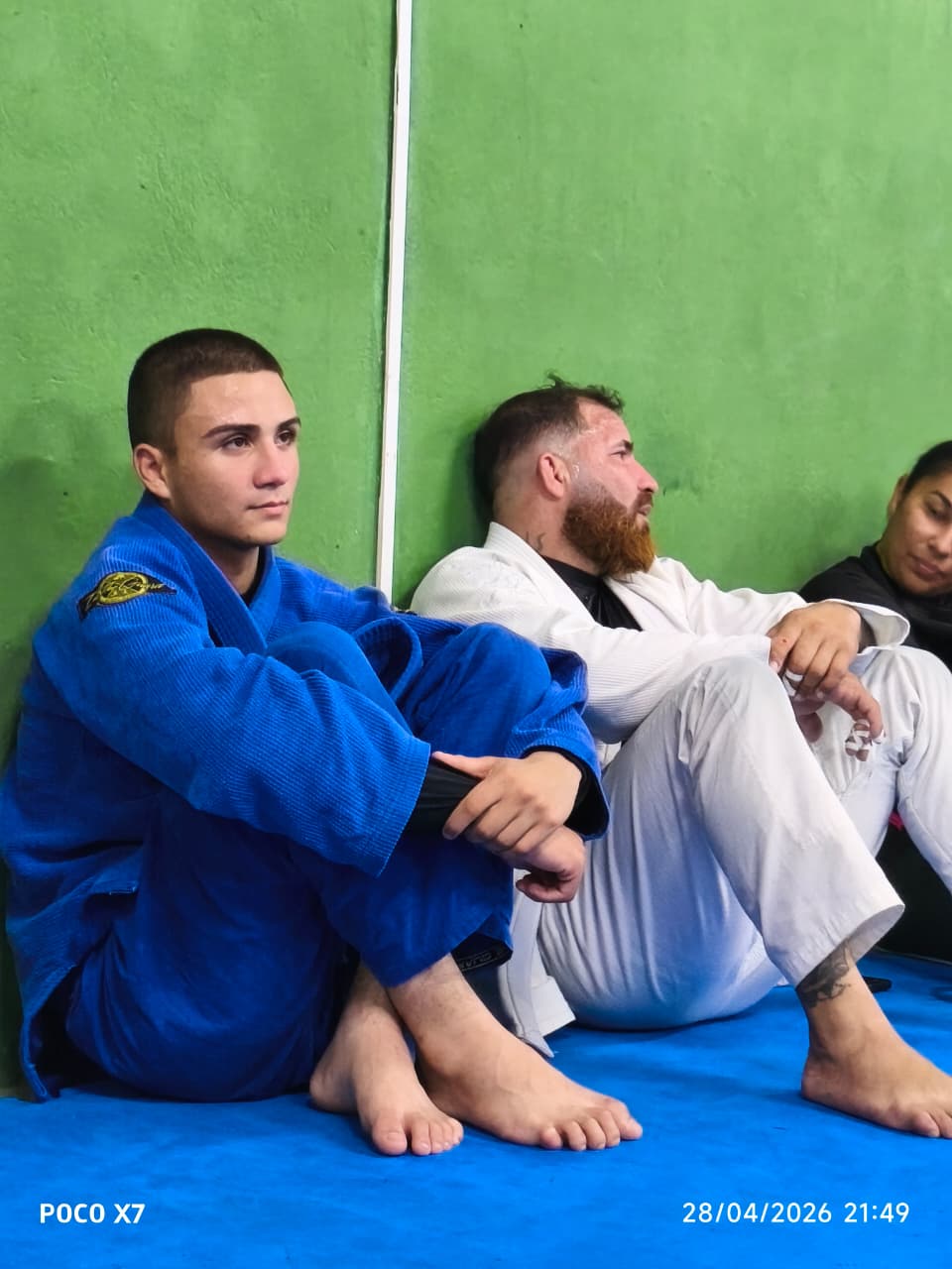 Atletas adultos descansando encostados na parede após treino