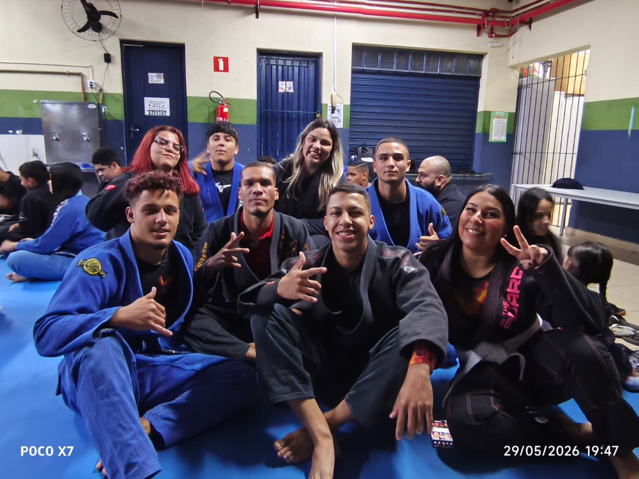 Grupo de jovens do Projeto Fênix reunidos no tatame